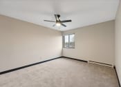 Thumbnail 40 of 44 - an empty living room with a ceiling fan and a window