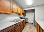 Thumbnail 28 of 44 - a kitchen with wooden cabinets and a sink and a refrigerator