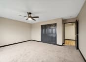 Thumbnail 35 of 44 - an empty living room with a ceiling fan and a door