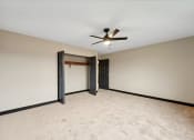 Thumbnail 39 of 44 - an empty living room with a ceiling fan and a door to a closet