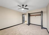 Thumbnail 37 of 44 - a empty living room with a ceiling fan and a garage door