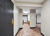 Thumbnail 32 of 44 - an empty hallway with a black door and white walls and wood floors