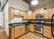Thumbnail 8 of 35 - a kitchen with wooden cabinets and stainless steel appliances