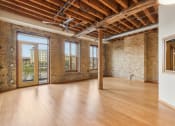 Thumbnail 1 of 35 - an empty living room with exposed brick walls and wood floors