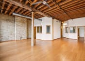 Thumbnail 5 of 35 - an empty room with wood floors and exposed ceilings