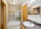 Thumbnail 18 of 35 - a bathroom with a sink and a shower and a mirror