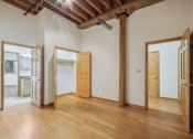 Thumbnail 16 of 35 - an empty living room with wood floors and white walls