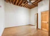 Thumbnail 17 of 35 - an empty room with wooden floors and a wooden door