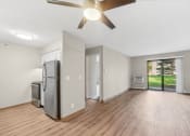 Thumbnail 1 of 21 - an empty living room with a refrigerator and a ceiling fan