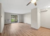 Thumbnail 11 of 21 - an empty living room with wood floors and a ceiling fan
