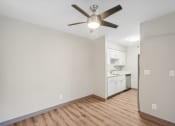 Thumbnail 15 of 21 - an empty living room with a ceiling fan and a kitchen