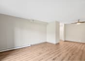 Thumbnail 17 of 21 - an empty living room with wood flooring and white walls