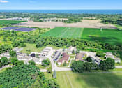 Thumbnail 12 of 52 - A bird's eye view of a residential area with houses, trees, and a large open field.