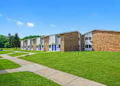 Thumbnail 1 of 52 - A series of small brick houses with blue doors and windows.