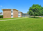 Thumbnail 4 of 52 - A building with a green lawn in front of it.