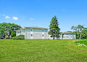 Thumbnail 5 of 52 - A white house with a green lawn in front of it.