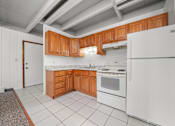 Thumbnail 29 of 52 - A kitchen with white appliances and wooden cabinets.