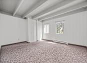 Thumbnail 43 of 52 - A room with white walls and a window with a view of trees.