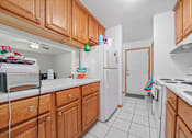 Thumbnail 30 of 52 - A kitchen with wooden cabinets and white appliances.