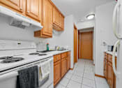 Thumbnail 33 of 52 - A kitchen with white appliances and wooden cabinets.
