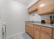 Thumbnail 35 of 52 - A kitchen with wooden cabinets and a granite countertop.