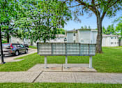 Thumbnail 18 of 52 - A green sign with many small squares is in the foreground of a residential area.