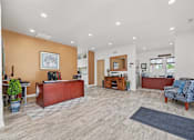 Thumbnail 21 of 52 - A spacious office with a brown desk and a blue patterned chair.