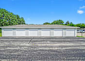Thumbnail 22 of 52 - A large white building with a grey roof and six garage doors.