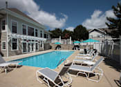 Thumbnail 13 of 44 - A pool with sun loungers and a building in the background.