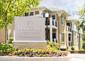 Thumbnail 3 of 31 - A sign for PrairieWalk at Towne Centre stands in front of a building.