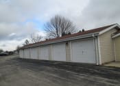 Thumbnail 4 of 5 - a row of three car garages with white doors and a red roof