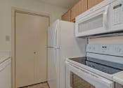 Thumbnail 28 of 48 - A white refrigerator and microwave in a kitchen.