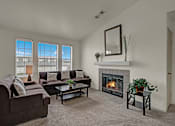 Thumbnail 18 of 48 - A living room with a fireplace and a couch.