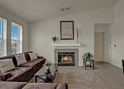 Thumbnail 19 of 48 - A living room with a fireplace and a couch.