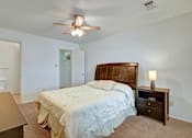 Thumbnail 22 of 48 - A bedroom with a bed, nightstand, and ceiling fan.