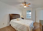 Thumbnail 21 of 48 - A bedroom with a large bed and a ceiling fan.