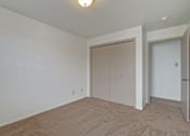 Thumbnail 32 of 48 - A room with a carpeted floor and two doors.