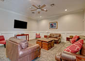 Thumbnail 6 of 48 - A living room with a brown leather couch and a flat screen TV mounted on the wall.
