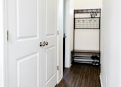 Thumbnail 59 of 60 - A hallway with a white door and a black rack on the wall.