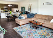 Thumbnail 55 of 60 - A living room with a couch, chairs, and a coffee table.