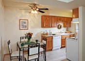 Thumbnail 1 of 33 - A kitchen with a table and chairs and a fridge.