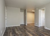 Thumbnail 22 of 27 - A room with wooden floors and white walls.
