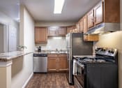 Thumbnail 13 of 27 - A kitchen with a black stove top oven and a refrigerator.
