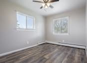 Thumbnail 24 of 27 - A room with a ceiling fan and two windows.