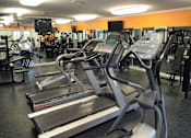 Thumbnail 16 of 44 - A gym with treadmills and other exercise equipment.