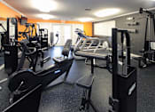 Thumbnail 17 of 44 - A gym with a variety of equipment including treadmills, weights, and exercise machines.