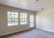 Thumbnail 36 of 48 - A room with a carpeted floor and a window with blinds.