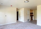Thumbnail 39 of 48 - A spacious living room with a carpeted floor and white walls.