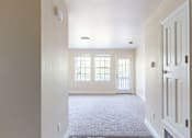 Thumbnail 42 of 48 - A hallway with a carpeted floor and white walls.