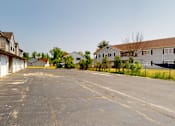Thumbnail 12 of 48 - A parking lot in front of a row of houses.